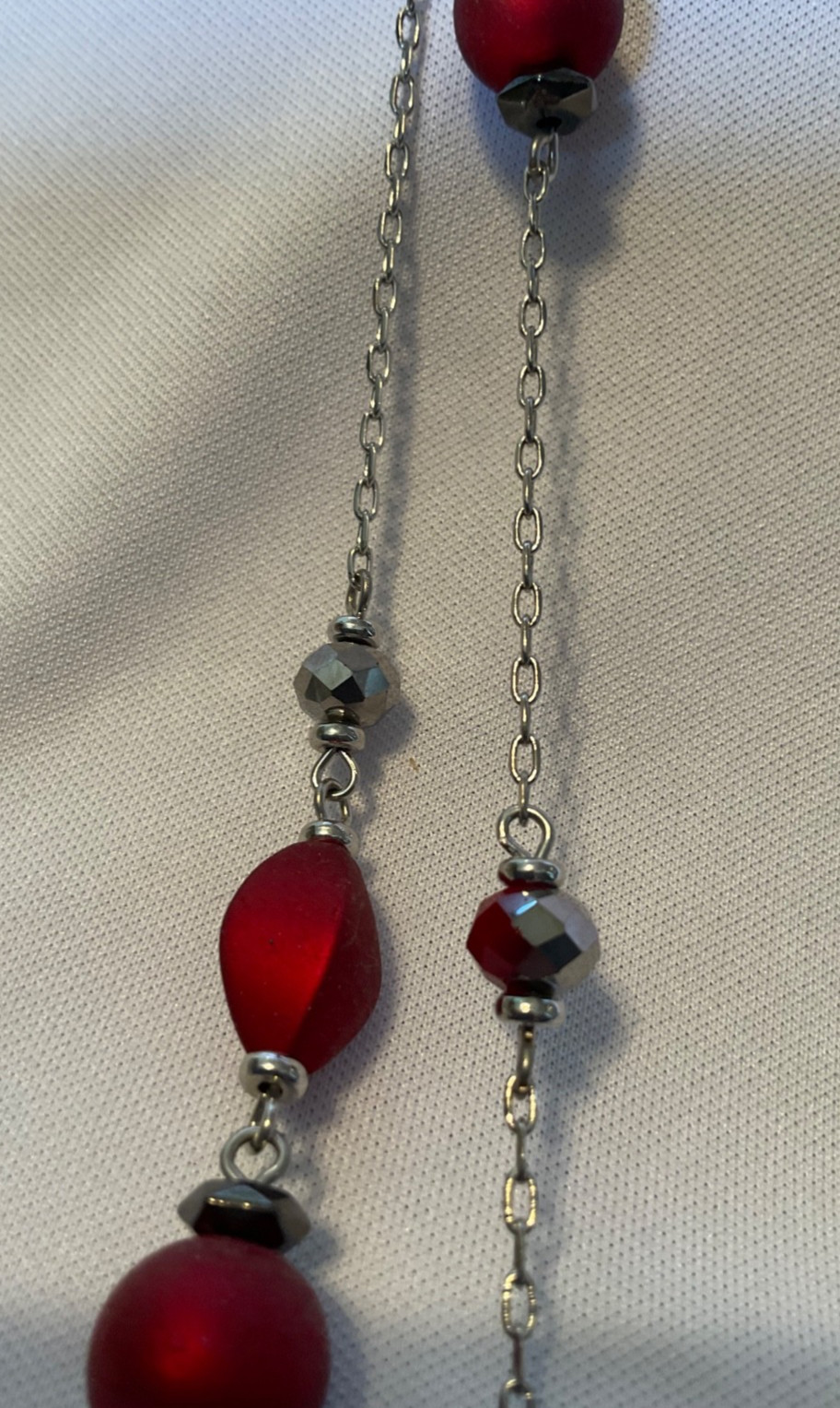Marked “ruby red”. Necklace features red beads with glassy beads on silver chn