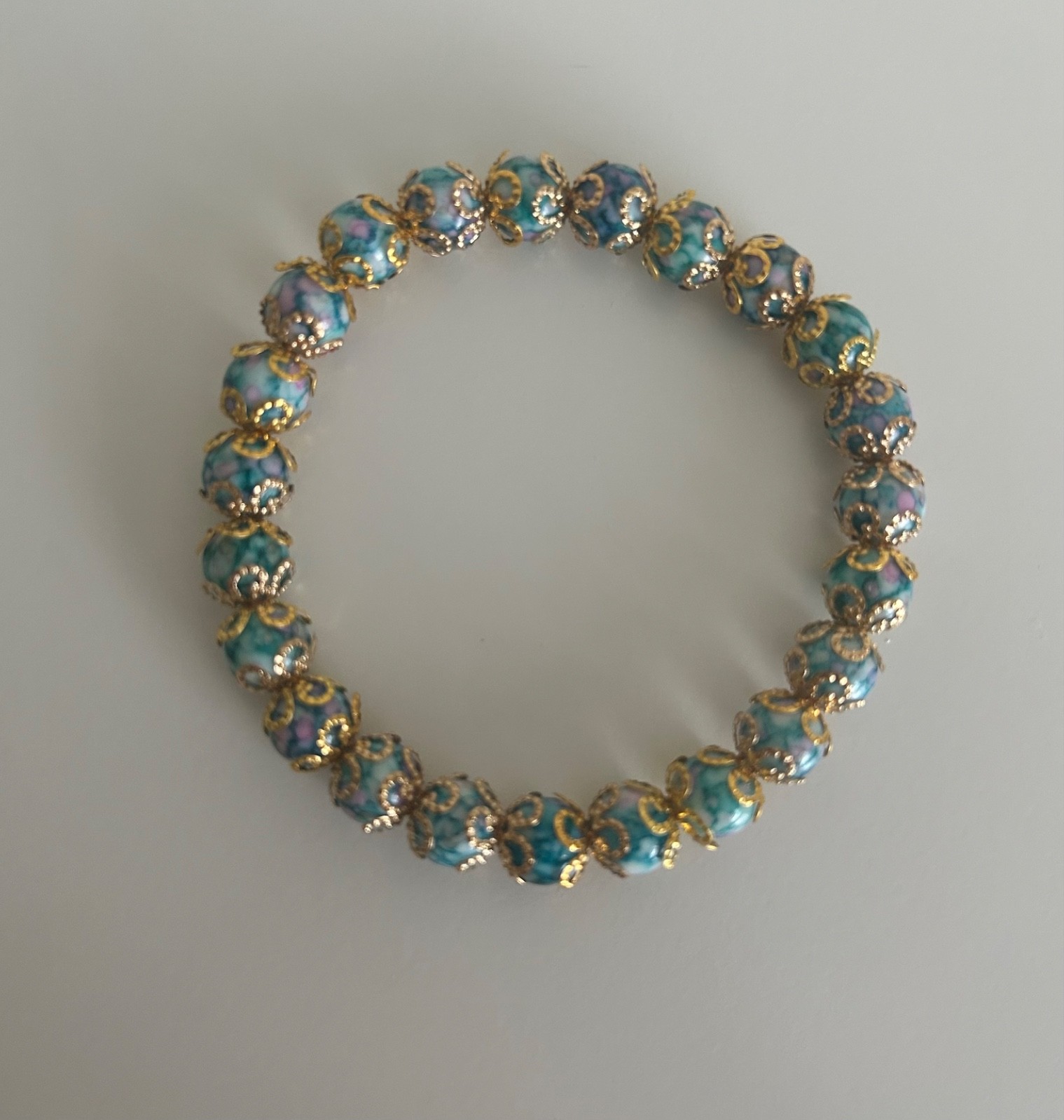 Ladies bracelet, blue marble affect beads covered with gold covered flowers S/M