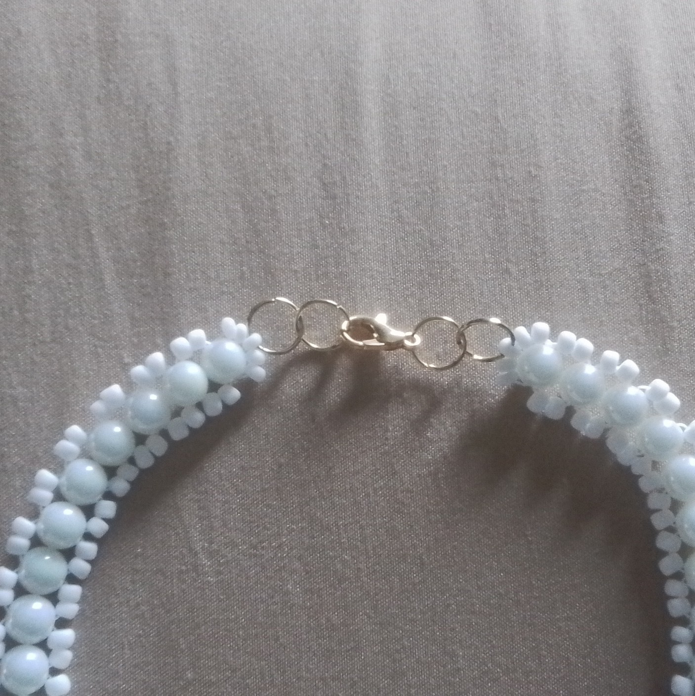 White shell beads, crystals, and small seed beads; necklace with a flower pendan
