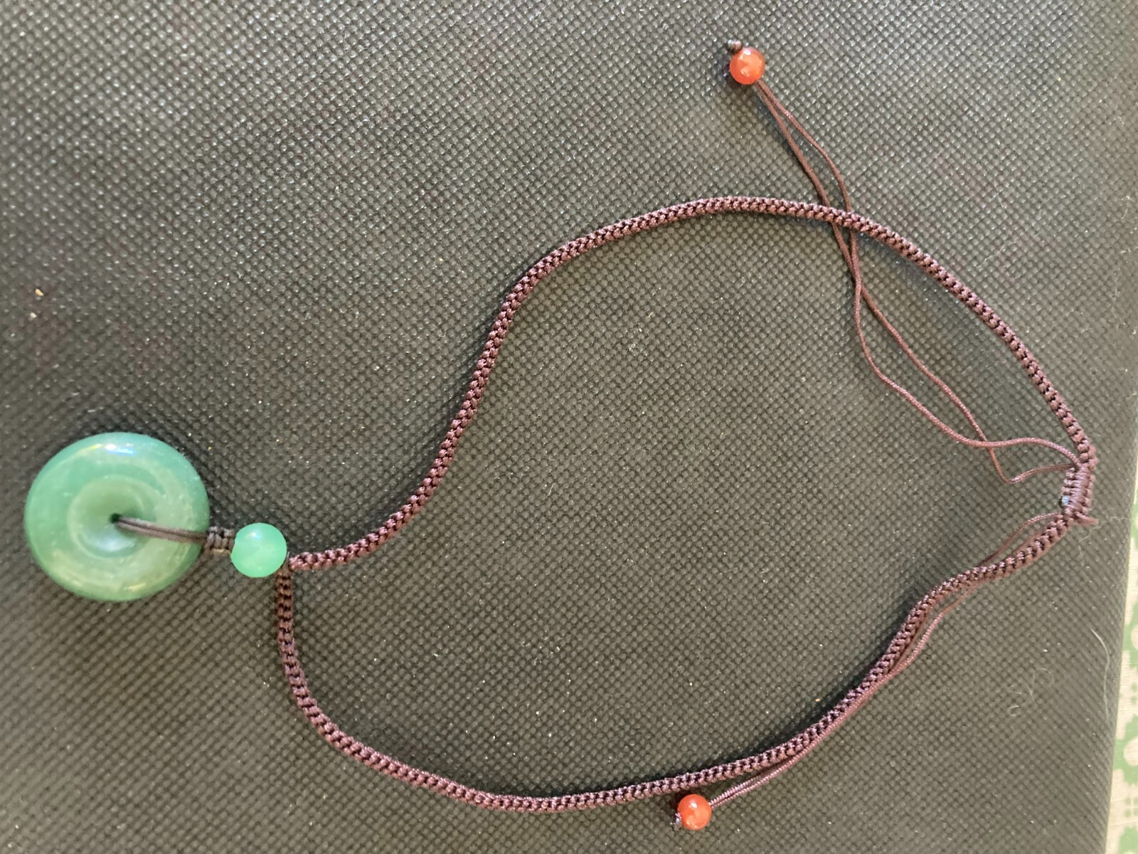 Necklace Carved Green Stone Pendant Circle and 3 stone beads woven with cord