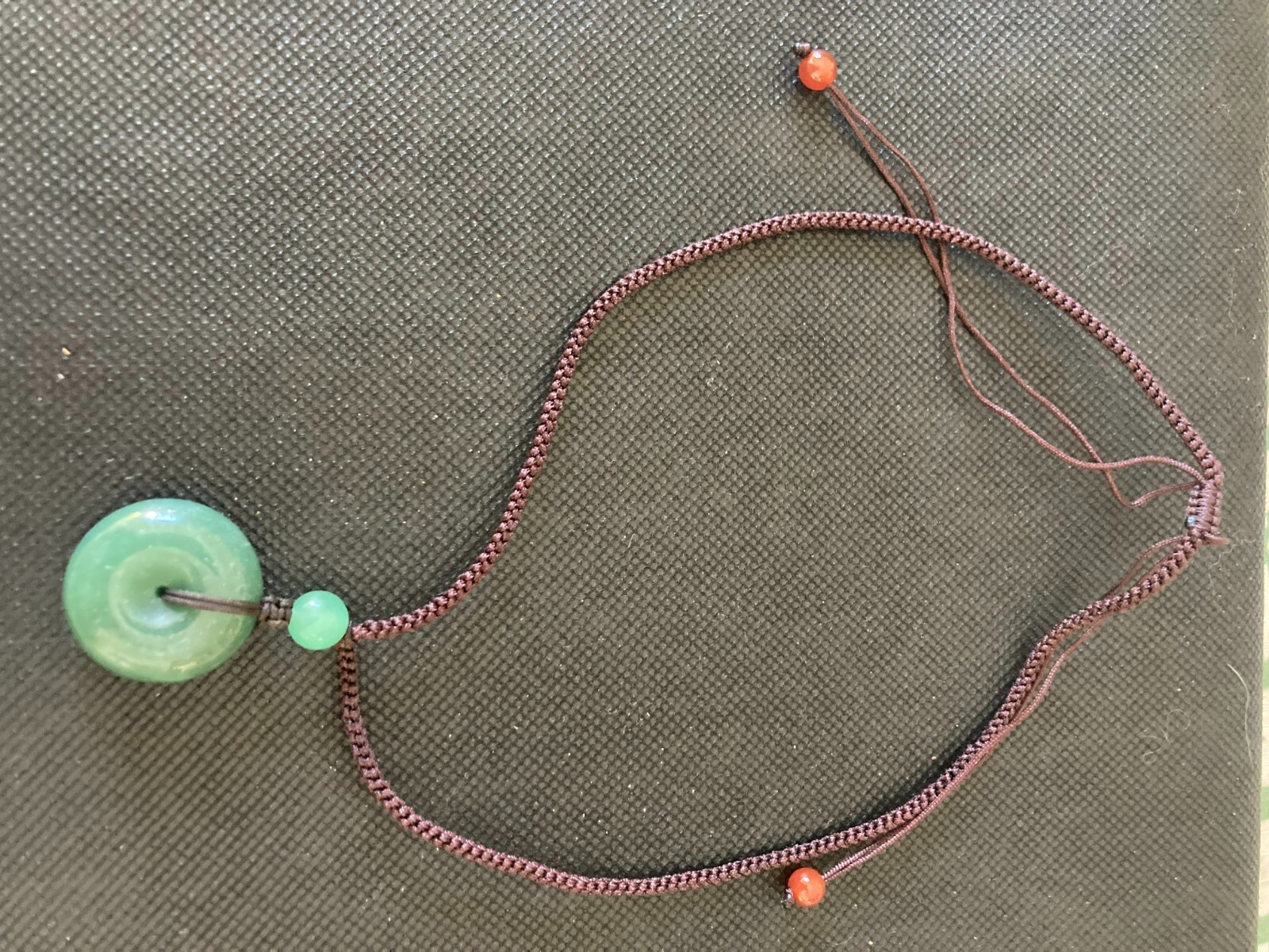 Necklace Carved Green Stone Pendant Circle and 3 stone beads woven with cord