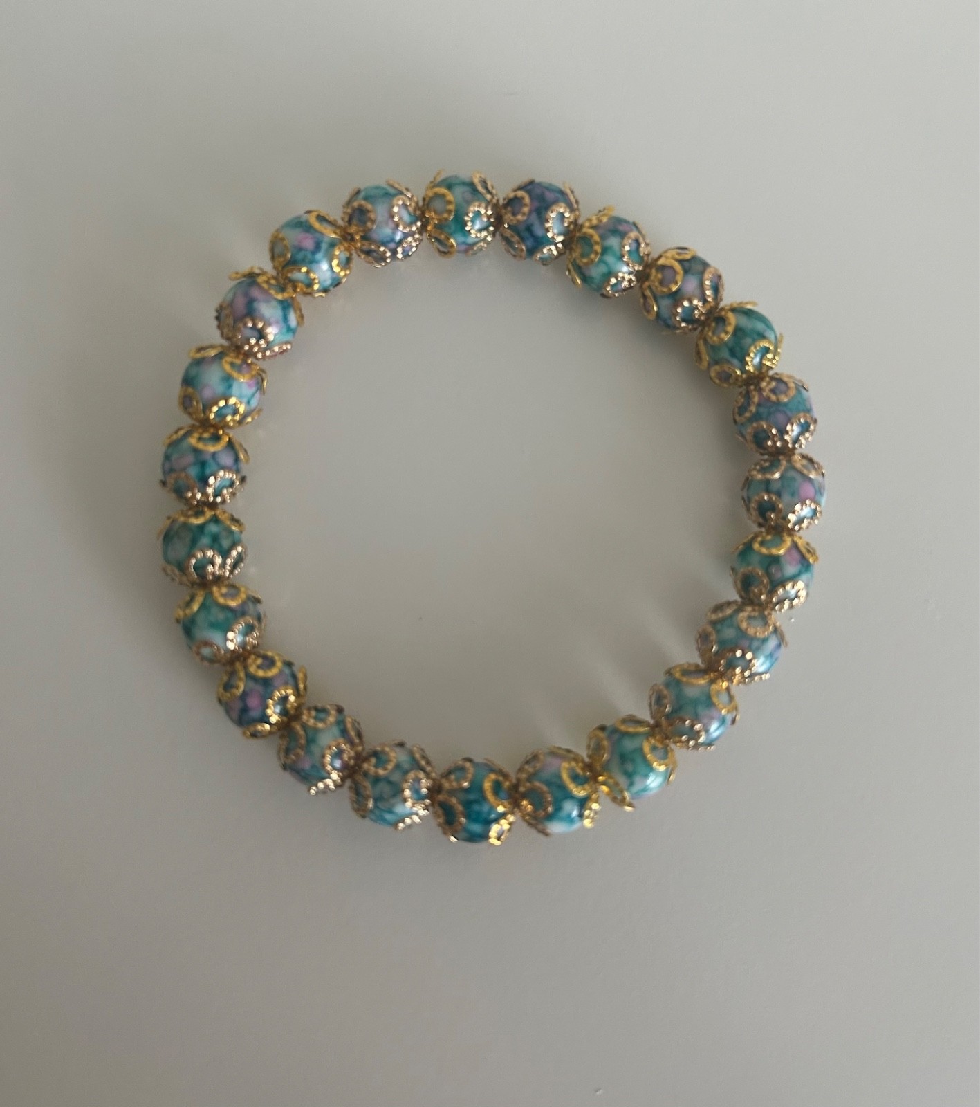 Ladies bracelet, blue marble affect beads covered with gold covered flowers S/M