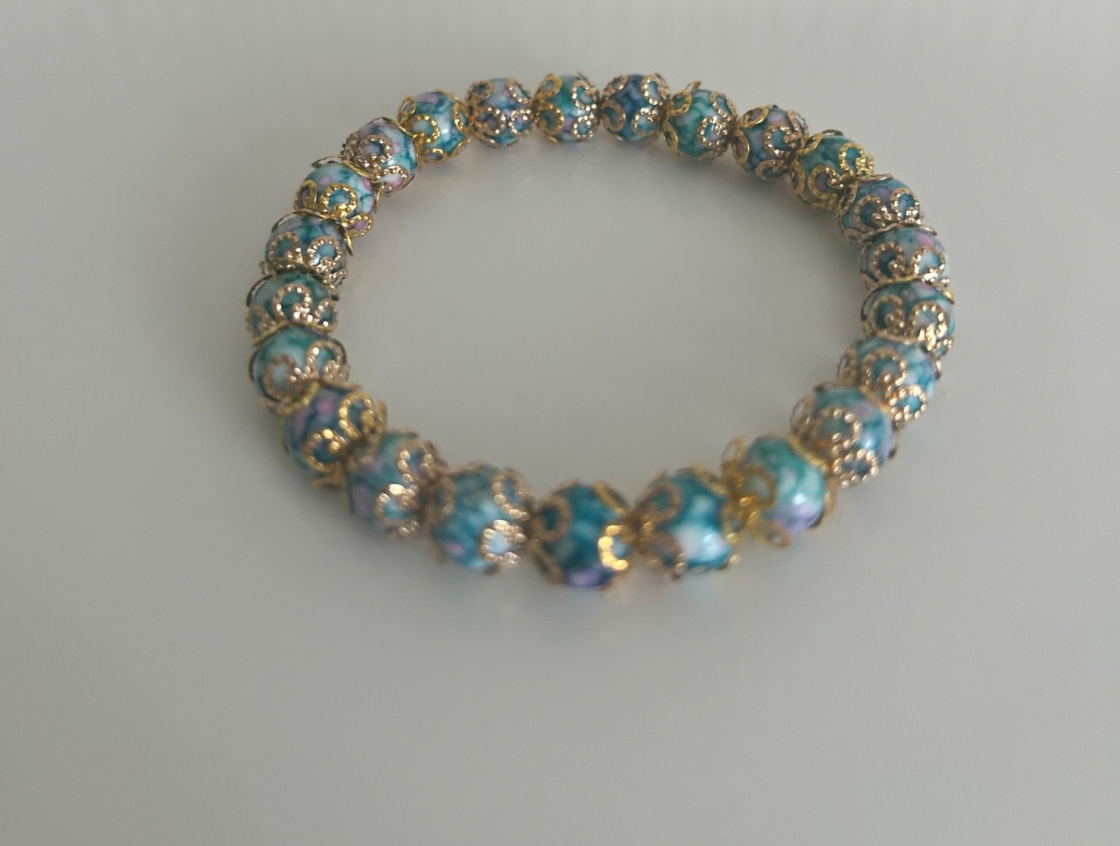 Ladies bracelet, blue marble affect beads covered with gold covered flowers S/M