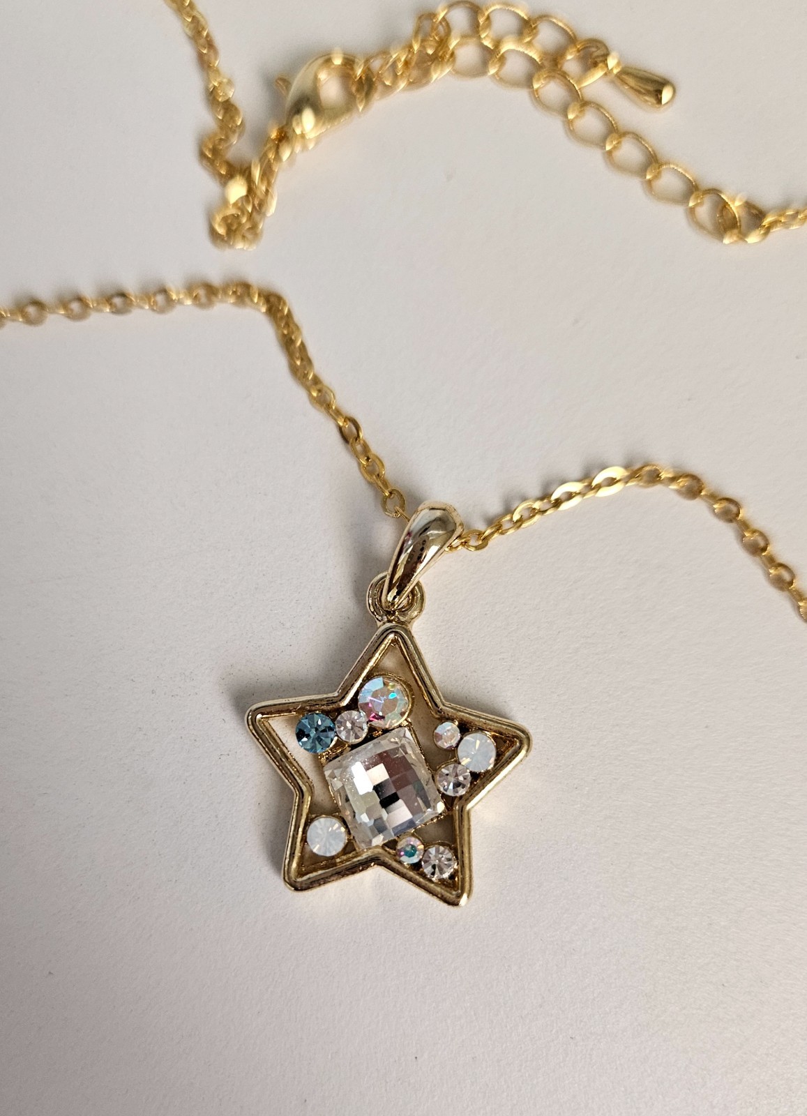 Gold-tone necklace featuring a star-shaped pendant filled with rhinestones